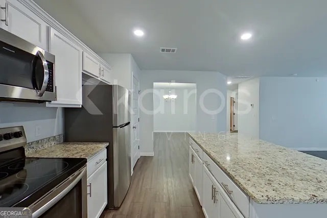 a kitchen with stainless steel appliances granite countertop a stove a sink and a refrigerator