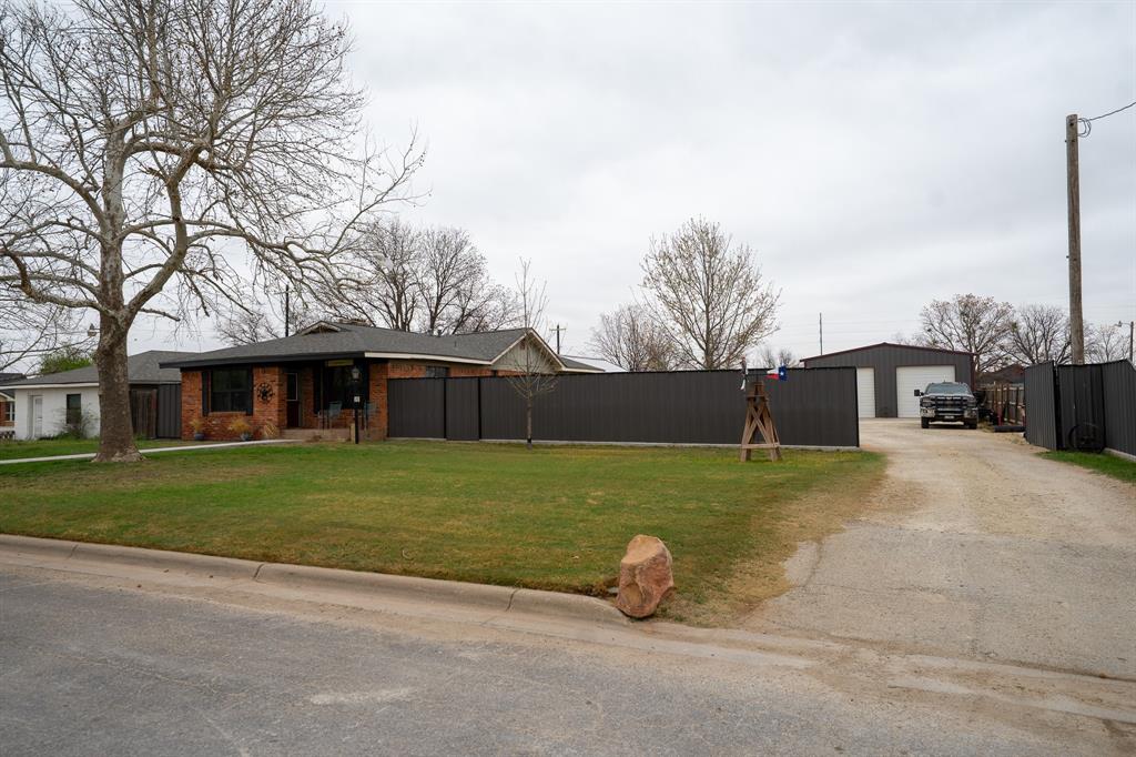 a view of a house with a yard and a street