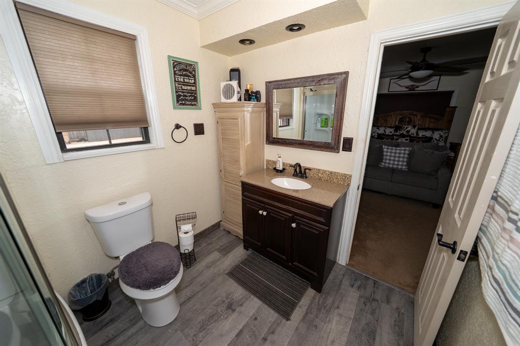 455 5th Street Hawley, TX 79525 - Photo 10 of 37 a bathroom with a toilet a sink and mirror