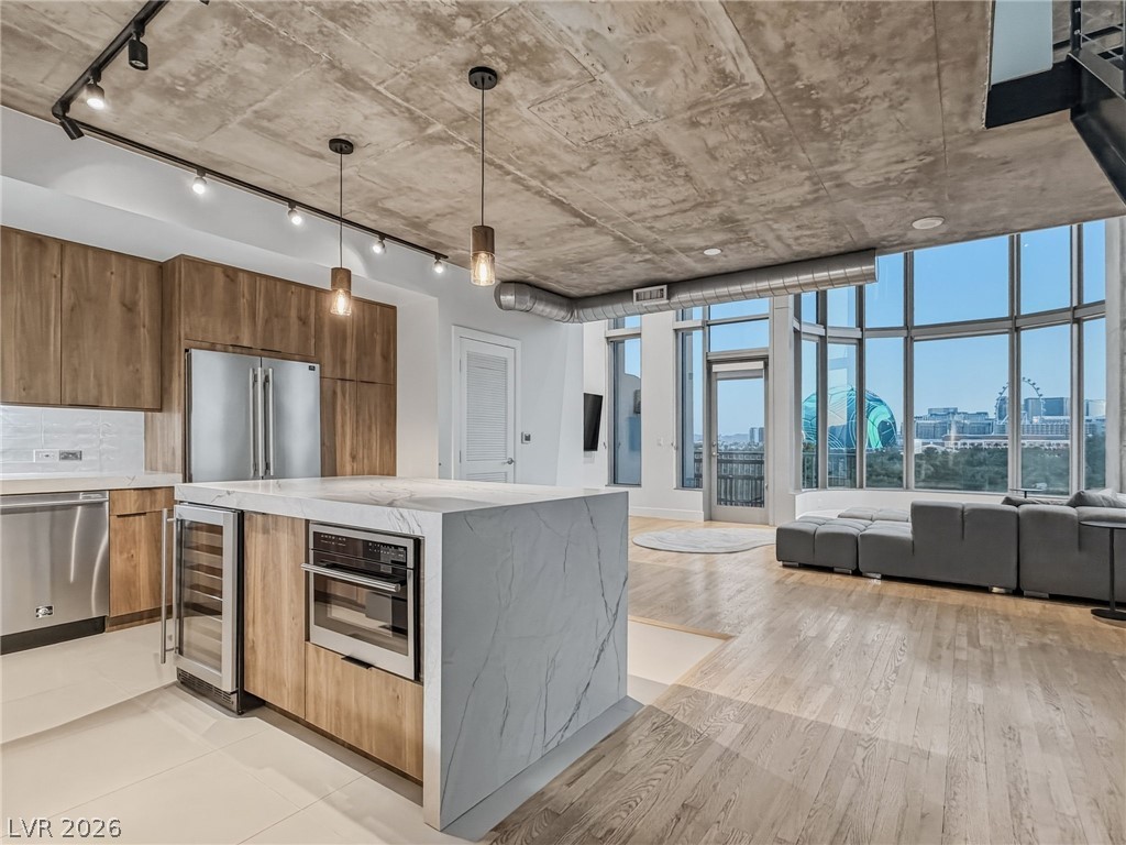 360 East Desert Inn Road, Unit 607 Las Vegas, NV 89109 - Photo 3 of 55 City views frame this open-concept kitchen and living area, complete with a contemporary island and sleek appliances.