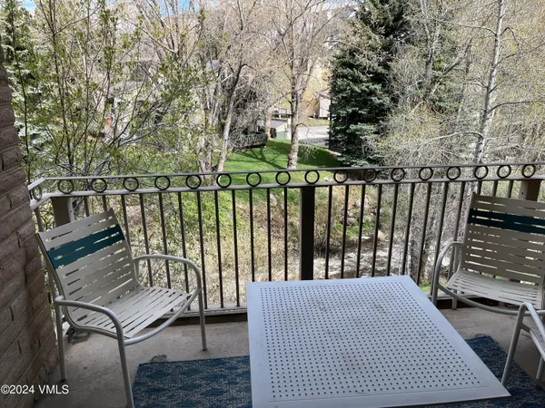 a balcony with wooden floor and outdoor seating