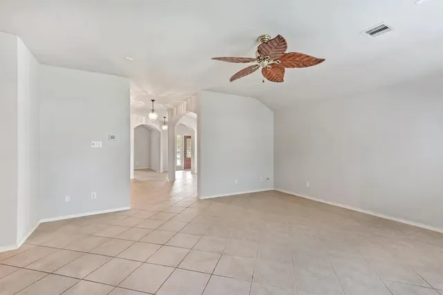 a view of a room with a ceiling fan and entryway