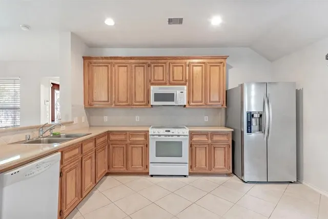 a kitchen with stainless steel appliances granite countertop a refrigerator sink and stove