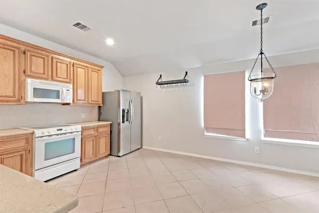 a kitchen with stainless steel appliances granite countertop a stove a sink and a refrigerator