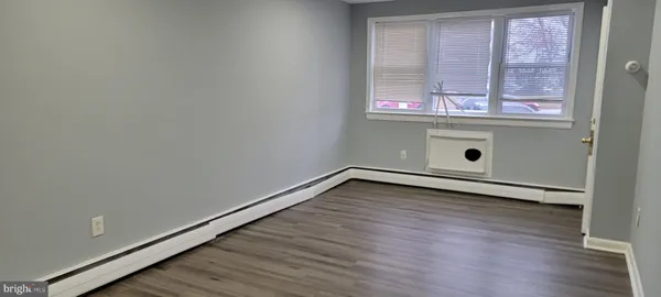 a view of a room with wooden floor and windows