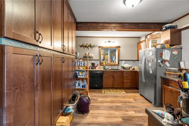 a kitchen with stainless steel appliances granite countertop a refrigerator and a wooden floor