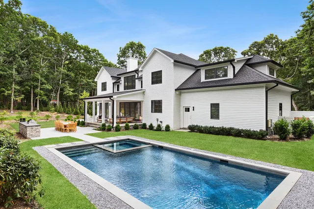 a view of a house with a yard patio and fire pit