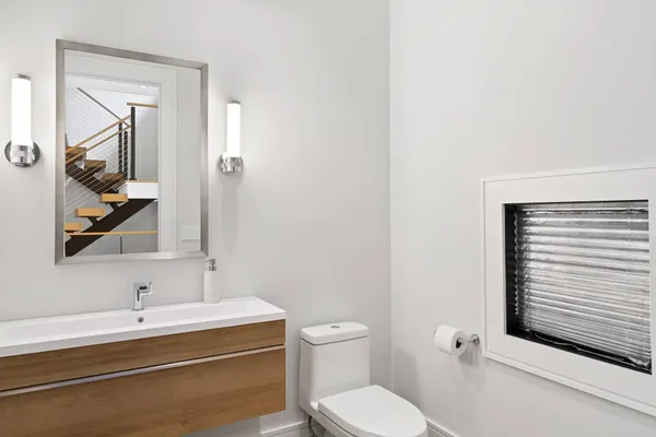a bathroom with a toilet a sink and mirror