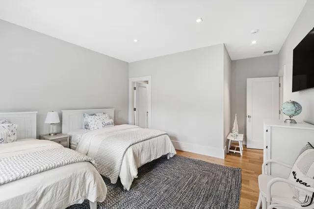 a bedroom with two beds and a flat screen tv