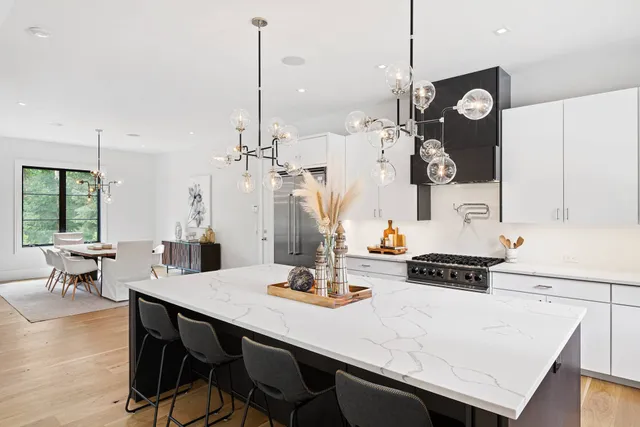 a kitchen with a table chairs and white cabinets