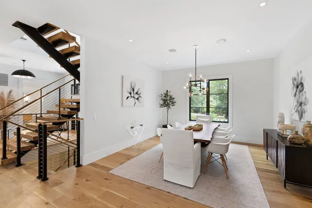 a living room with furniture a dining table and a large window