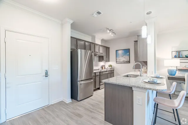 a kitchen with kitchen island a refrigerator stove microwave and cabinets