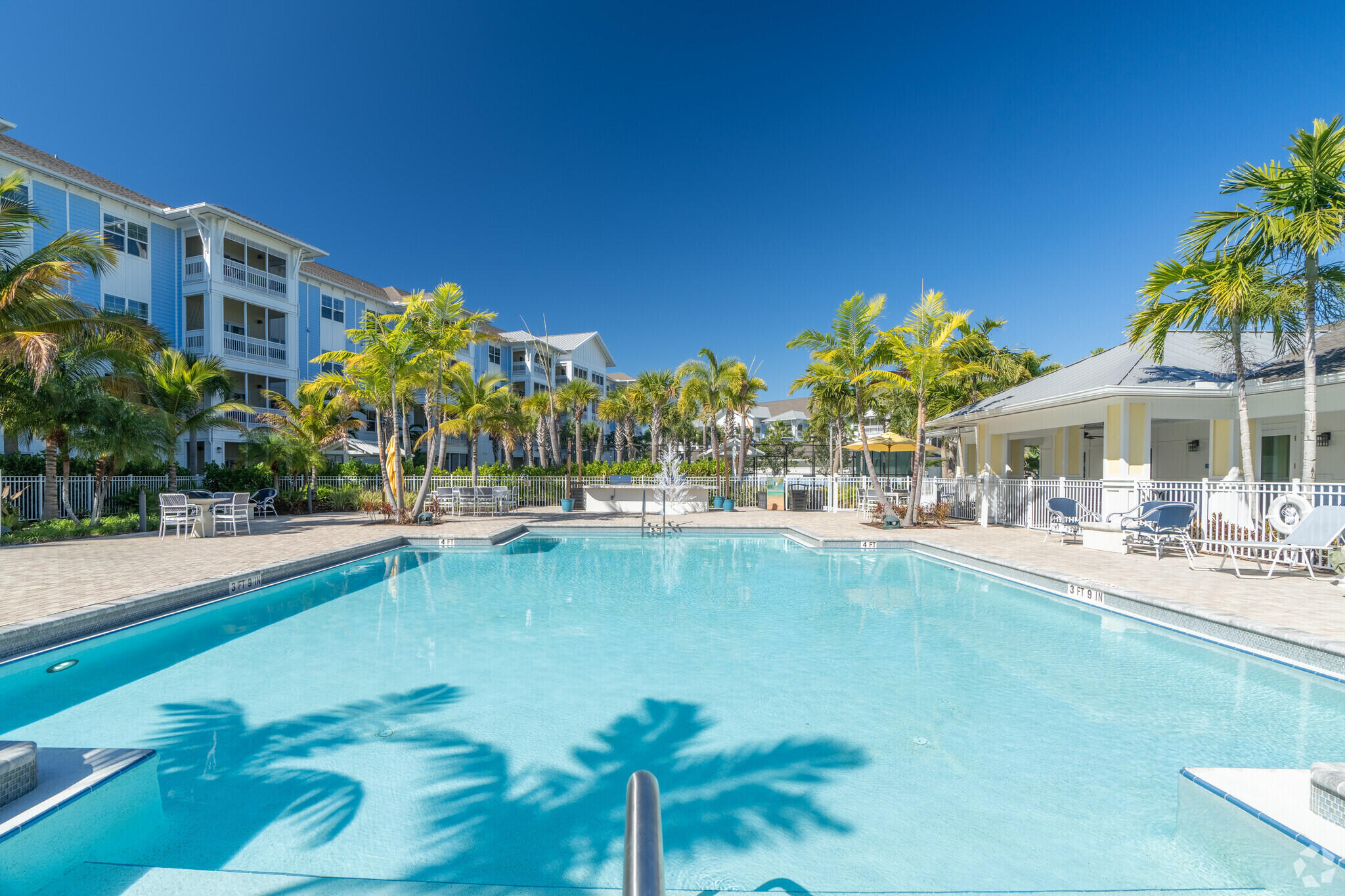1924 Northwest Federal Highway, Unit 1305 Stuart, FL 34994 - Photo 13 of 15 a view of swimming pool with outdoor seating and a garden