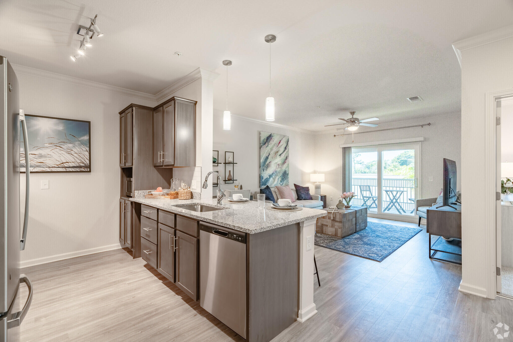1924 Northwest Federal Highway, Unit 1305 Stuart, FL 34994 - Photo 4 of 15 a view of a kitchen counter top space with stainless steel appliances wooden floor and living room view