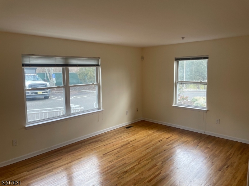1527 Lamberts Mill Road, Unit 1A Westfield, NJ 07090 - Photo 6 of 15 a view of an empty room with wooden floor and a window