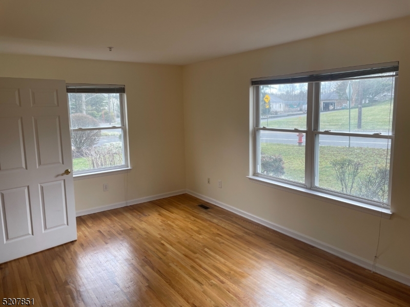 1527 Lamberts Mill Road, Unit 1A Westfield, NJ 07090 - Photo 9 of 15 a view of an empty room with wooden floor and a window