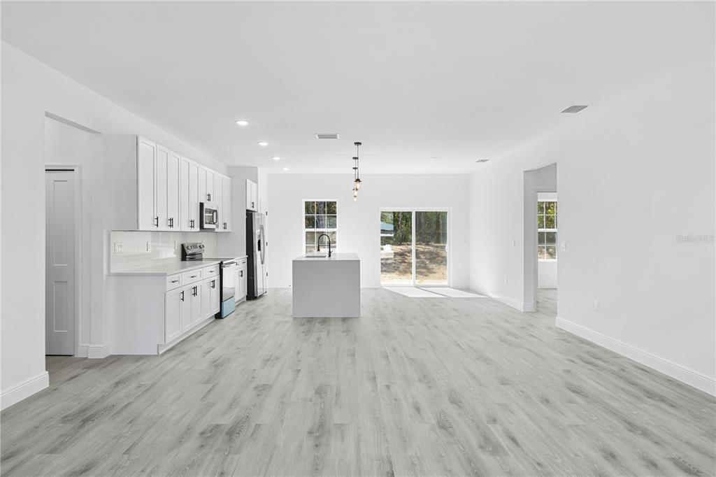 2640 West Fairway Loop Citrus Springs, FL 34434 - Photo 11 of 39 a large white kitchen with wooden floors and white walls