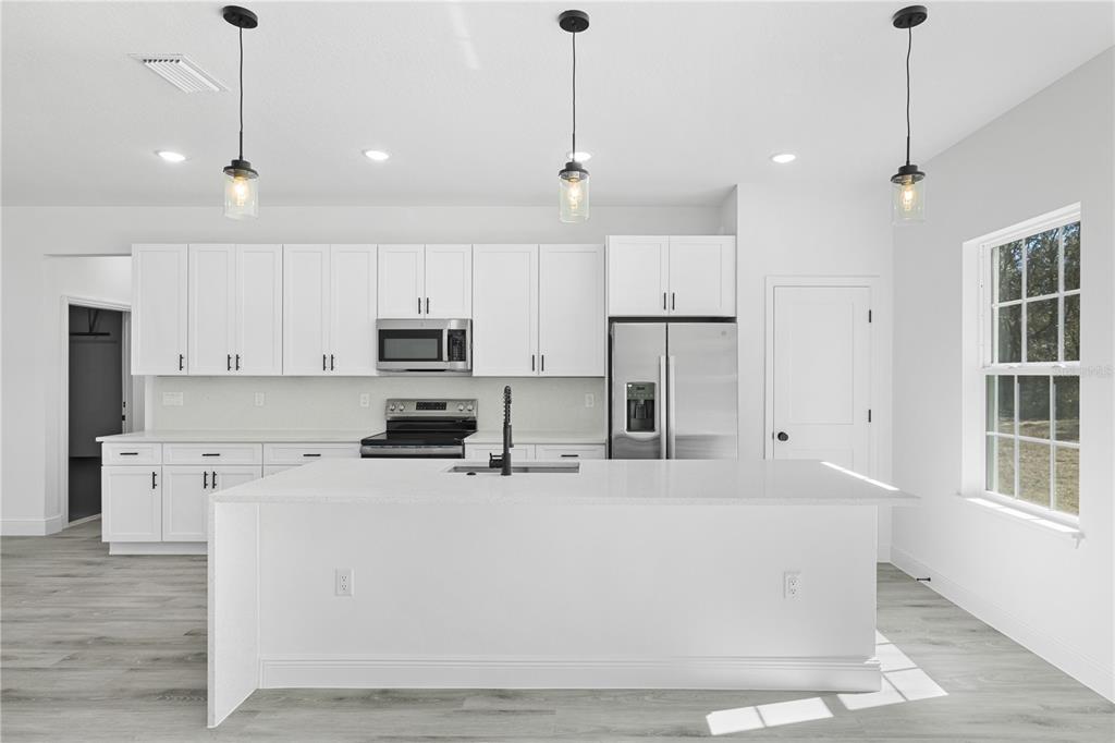 2640 West Fairway Loop Citrus Springs, FL 34434 - Photo 13 of 39 a kitchen with stainless steel appliances granite countertop a refrigerator a sink dishwasher a oven and white cabinets with wooden floor