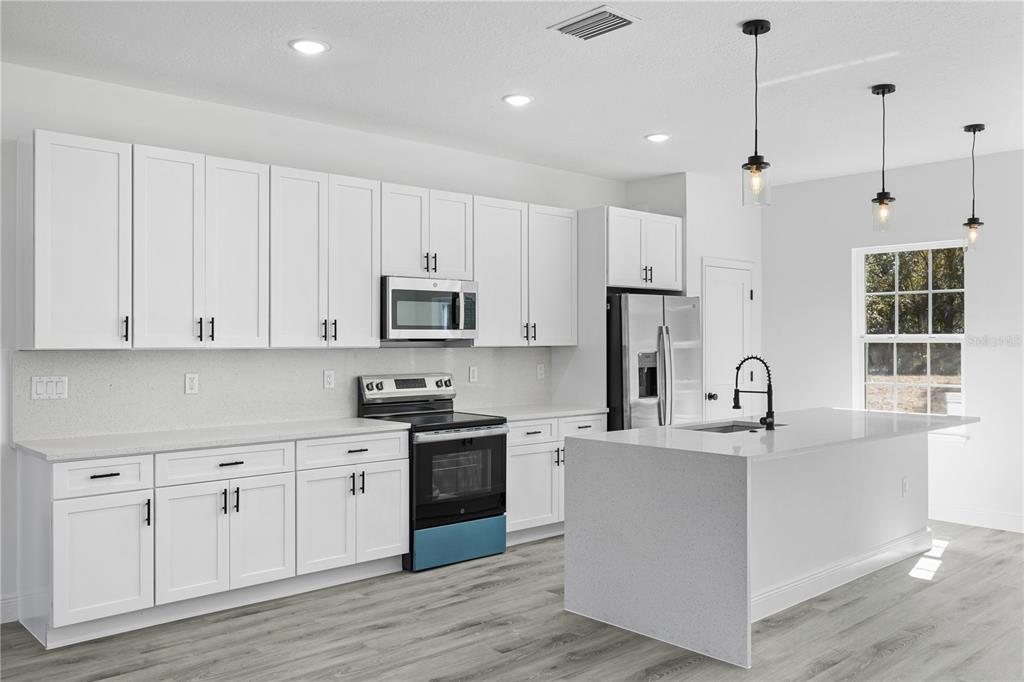 2640 West Fairway Loop Citrus Springs, FL 34434 - Photo 17 of 39 a kitchen with stainless steel appliances granite countertop a sink dishwasher a refrigerator and white cabinets with wooden floor