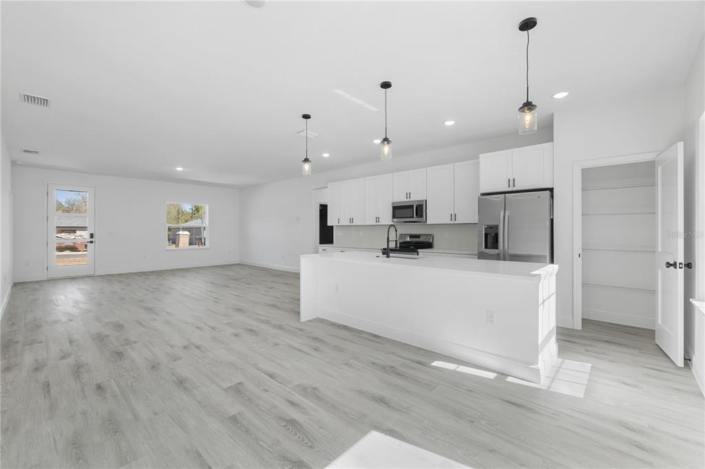 2640 West Fairway Loop Citrus Springs, FL 34434 - Photo 18 of 39 a view of a kitchen with center island stainless steel appliances wooden floor and window