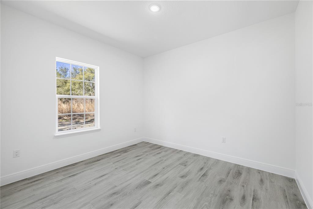 2640 West Fairway Loop Citrus Springs, FL 34434 - Photo 22 of 39 an empty room with wooden floor and windows