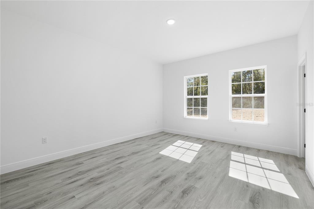 2640 West Fairway Loop Citrus Springs, FL 34434 - Photo 34 of 39 an empty room with wooden floor and windows
