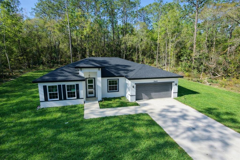 2640 West Fairway Loop Citrus Springs, FL 34434 - Photo 39 of 39 a front view of a house with a garden and yard