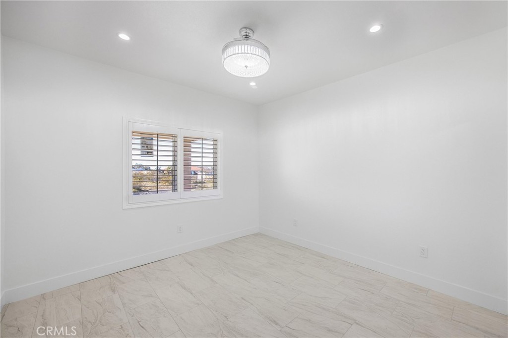11788 Buckwheat Road Pinon Hills, CA 92371 - Photo 21 of 61 an empty room with a window and a fan