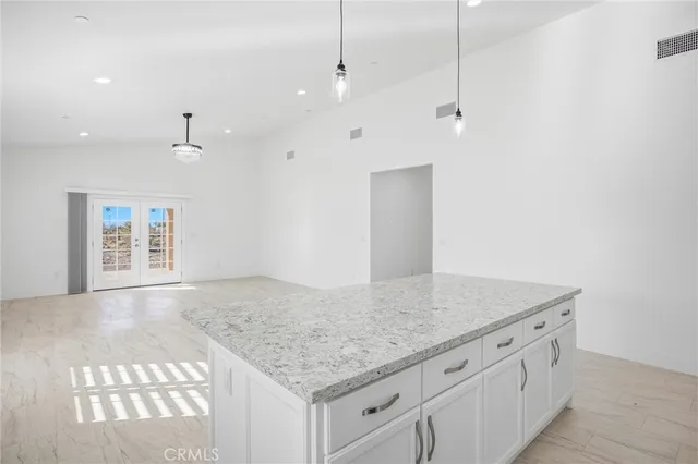 a large kitchen with stainless steel appliances granite countertop a stove a sink and a refrigerator