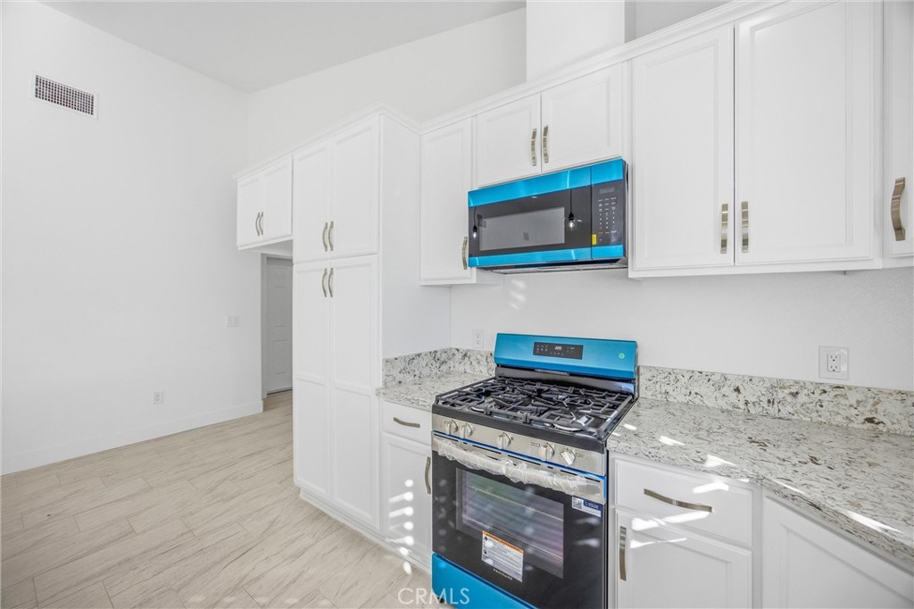 11788 Buckwheat Road Pinon Hills, CA 92371 - Photo 10 of 61 a kitchen with stainless steel appliances granite countertop white cabinets and a stove top oven