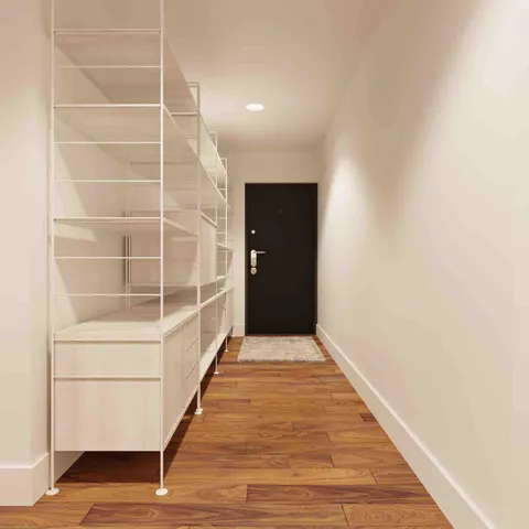 a view of an empty room with wooden floor and entryway