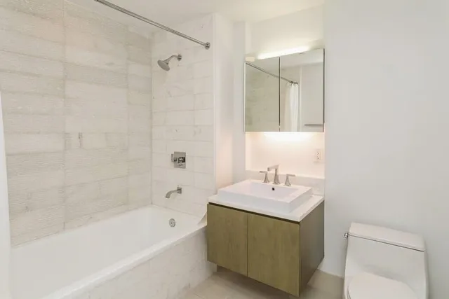 a bathroom with a sink vanity tub and shower