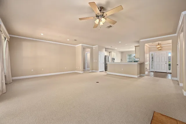 a view of a livingroom with a ceiling fan window and a kitchen