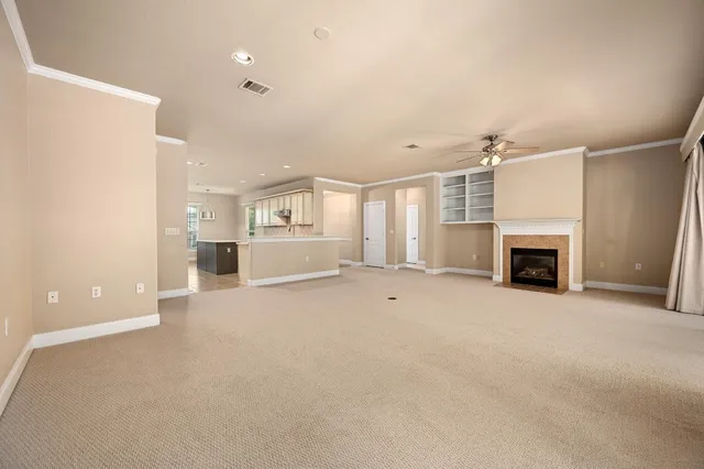 an empty room with kitchen and fireplace