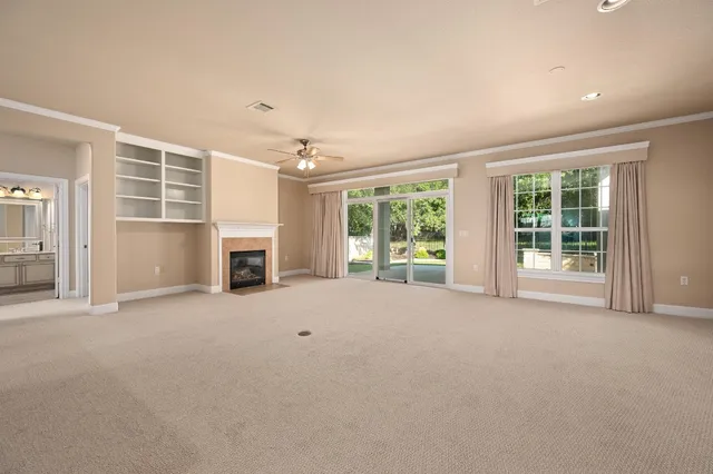 en empty room with windows and fireplace