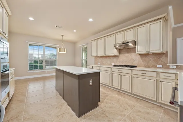 a kitchen with granite countertop a sink and white cabinets