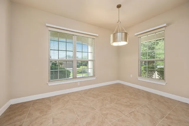 an empty room with windows and chandelier