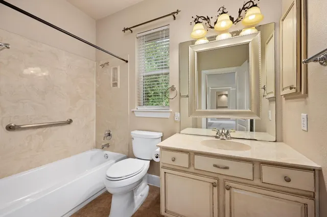 a bathroom with a sink vanity mirror and toilet