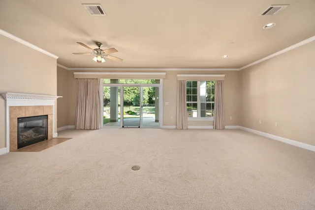 a view of an empty room with window and fire place