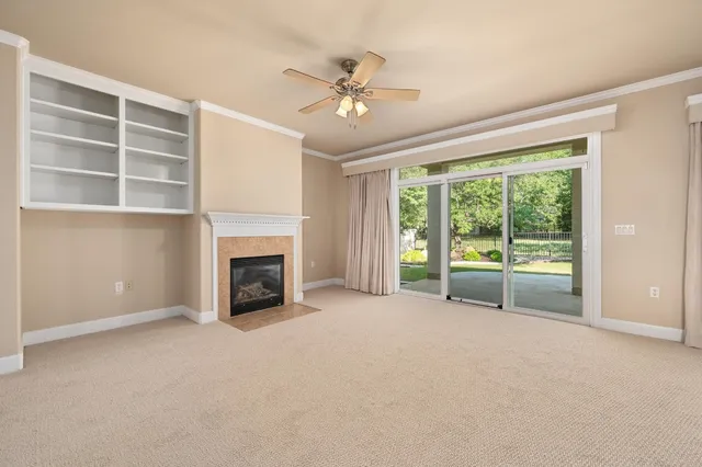a view of an empty room with a fireplace and a window