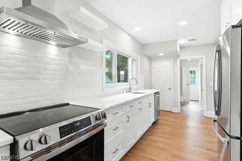 a view of a kitchen with a stove wooden floor and windows