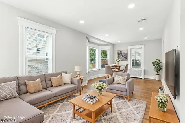 a living room with furniture flat screen tv and a large window