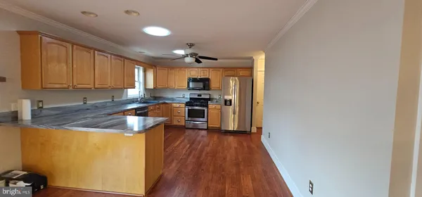 a kitchen with granite countertop stainless steel appliances a stove top oven a sink and a granite counter tops