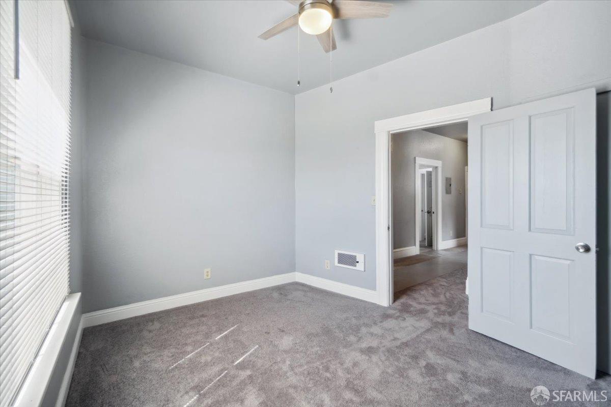 1309 80th Avenue Oakland, CA 94621 - Photo 17 of 75 an empty room with a ceiling fan and a window