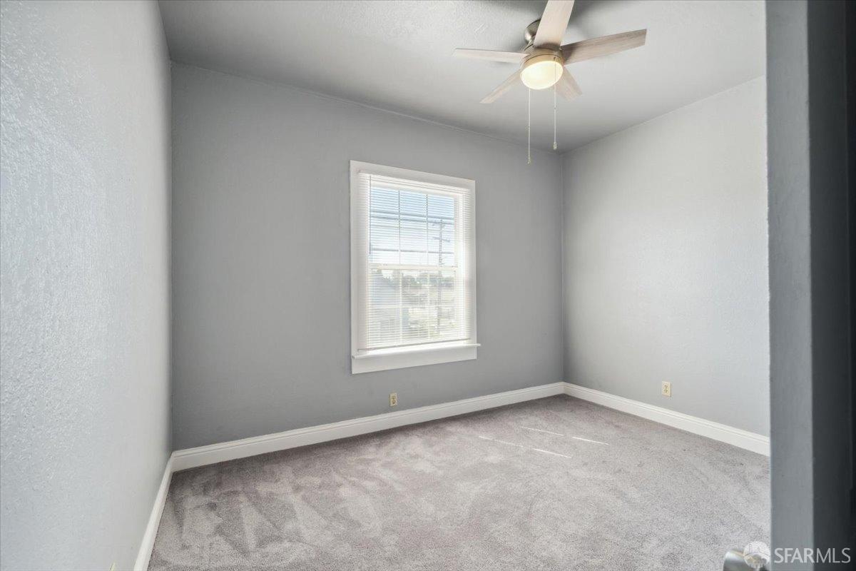 1309 80th Avenue Oakland, CA 94621 - Photo 18 of 75 an empty room with a window and ceiling fan