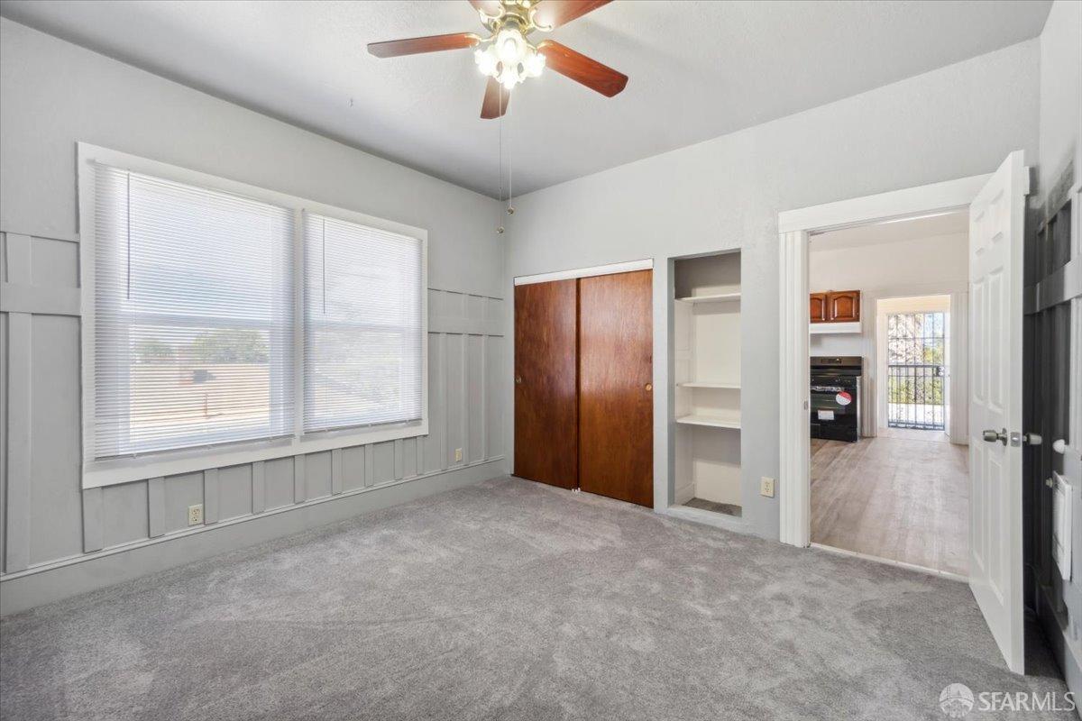 1309 80th Avenue Oakland, CA 94621 - Photo 21 of 75 an empty room with chandelier fan and windows