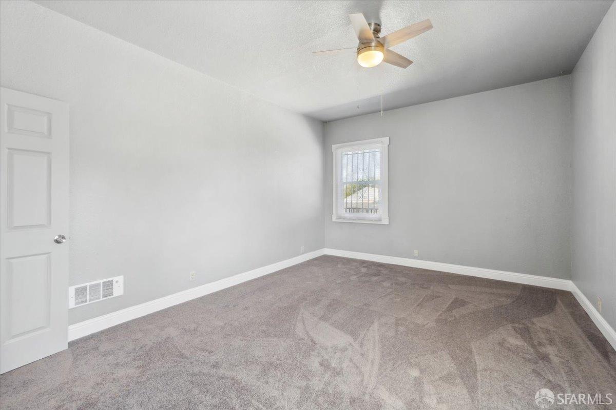 1309 80th Avenue Oakland, CA 94621 - Photo 25 of 75 an empty room with windows and fan