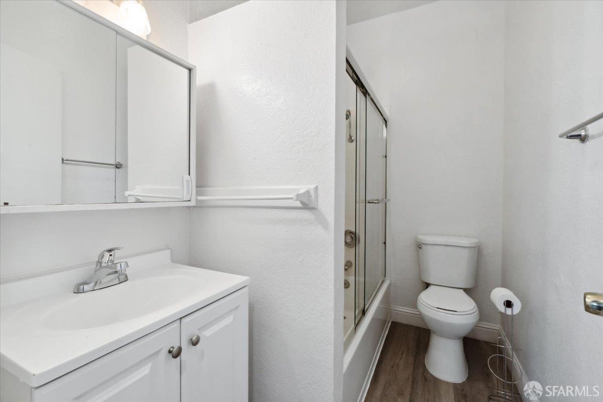 1309 80th Avenue Oakland, CA 94621 - Photo 28 of 75 a bathroom with a toilet sink and mirror