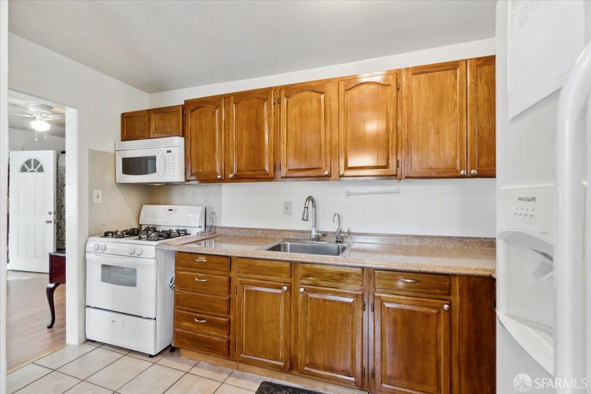 1309 80th Avenue Oakland, CA 94621 - Photo 42 of 75 a kitchen with stainless steel appliances granite countertop a sink stove and microwave