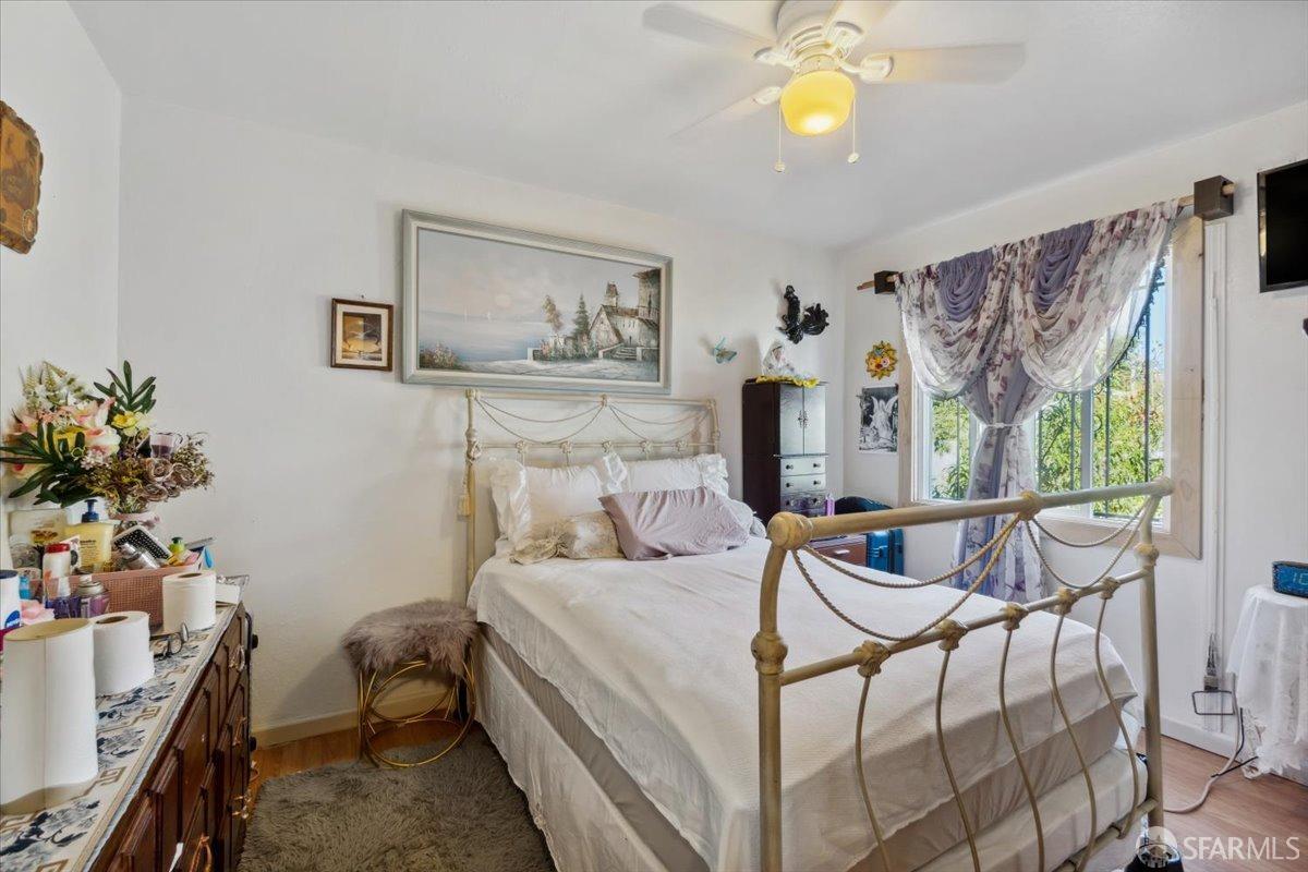 1309 80th Avenue Oakland, CA 94621 - Photo 47 of 75 a bedroom with a bed and a chandelier